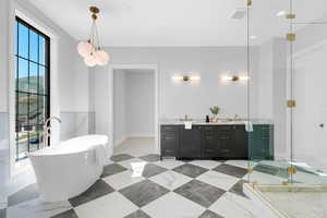 Full bathroom featuring double vanity, a freestanding bath, and a shower stall