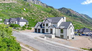 View of front facade with asphalt driveway, stucco siding, a garage, and a mountain view