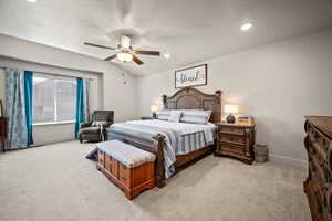 Primary Bedroom featuring carpet floors, baseboards, vaulted ceiling, a textured ceiling, and ceiling fan