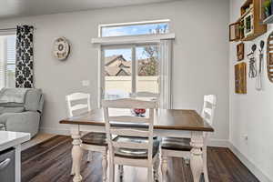 Dining room featuring dark wood-style floors and baseboards