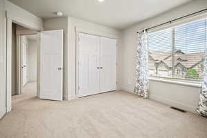Bedroom 2 featuring carpet, multiple windows, baseboards, and a closet
