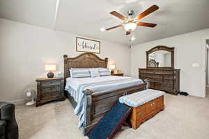 Primary Bedroom featuring light carpet, baseboards, and a ceiling fan