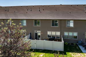 Rear view of property with stucco siding, central air condition unit, and a shingled roof