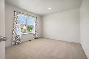 Bedroom 2  baseboards, light carpet, and recessed lighting