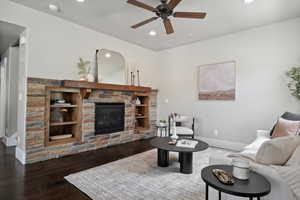 Living room with ceiling fan, a stone fireplace, recessed lighting, wood-type flooring, and baseboards