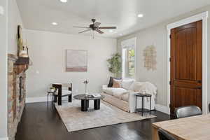 Living room with a ceiling fan, recessed lighting, baseboards, and dark wood-type flooring
