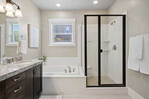 Bathroom featuring vanity, a shower stall, a garden tub, tile patterned flooring, and recessed lighting