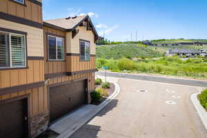 View of side of home with a shingled roof, board and batten siding, and an attached garage