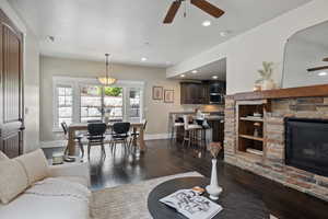 Living room with ceiling fan, dark wood-style floors, baseboards, recessed lighting, and a fireplace