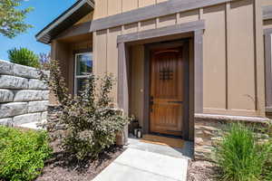 View of exterior entry featuring stone siding and board and batten siding