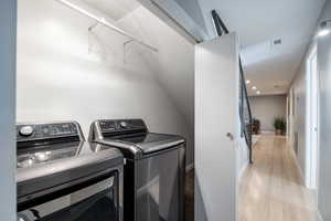 Washroom with washer and dryer, recessed lighting, light wood-style flooring, and baseboards