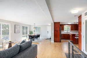 Living area with light wood finished floors, baseboards, and a textured ceiling