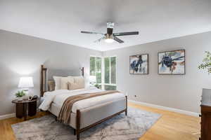 Bedroom featuring baseboards, light wood finished floors, and a ceiling fan