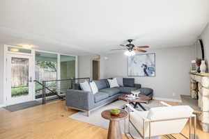 Living room featuring baseboards, wood finished floors, and ceiling fan