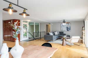 Living area featuring wood finished floors, plenty of natural light, and a ceiling fan