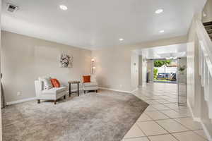 Living area with a chandelier, recessed lighting, baseboards, and light tile patterned flooring