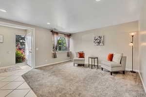Living area with baseboards, tile patterned floors, recessed lighting, and carpet