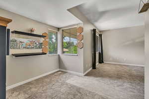 Spare room featuring carpet and baseboards