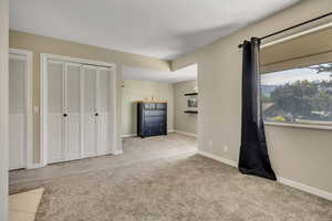 Unfurnished living room with carpet floors and baseboards
