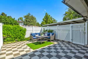 Fenced backyard featuring an outdoor hangout area and a patio