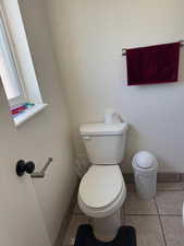 Half bath with toilet and tile patterned floors