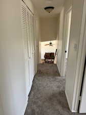 Corridor with dark carpet and baseboards