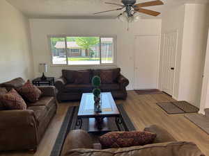 Living area with wood like vinyl finished floors and ceiling fan.
