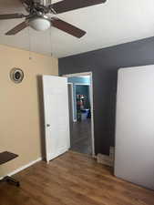 Unfurnished bedroom featuring wood finished floors, a textured ceiling, and ceiling fan