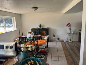Tiled dining area featuring a textured ceiling