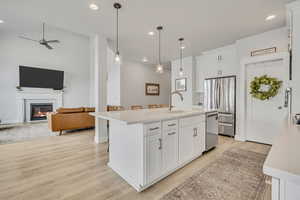 Kitchen featuring a sink, appliances with stainless steel finishes, light countertops, light wood finished floors, and a ceiling fan
