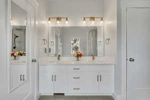 Full bathroom with a stall shower, double vanity, and tile patterned flooring