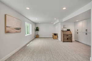 Sitting room with recessed lighting, light carpet, and baseboards