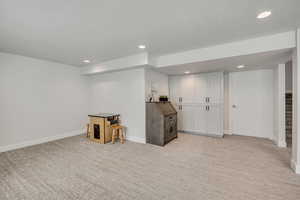 Below grade area with light carpet, recessed lighting, and baseboards