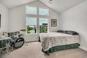 Bedroom with multiple windows, carpet, lofted ceiling, and baseboards
