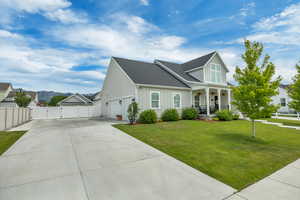 View of front of house featuring a gate, board and batten siding, covered porch, concrete driveway, and an attached garage