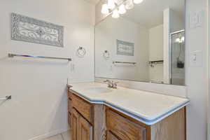 Full bathroom featuring vanity, a shower with shower door, toilet, and tile patterned floors