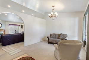 Living room featuring carpet, a chandelier, and recessed lighting