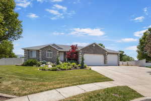 Ranch-style house with driveway, an attached garage, and brick siding