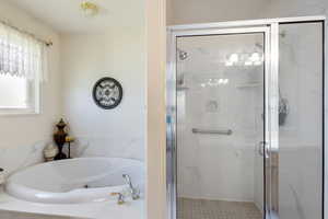 Bathroom with a shower stall and a whirlpool tub