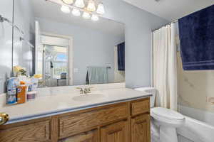 Full bath with vanity, toilet, and shower / bathtub combination with curtain
