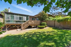 Rear view of house with a sunroom, a deck, and stairs