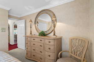 Bedroom featuring arched walkways, carpet flooring, a textured ceiling, and crown molding