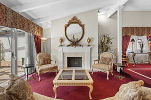 Living area featuring carpet flooring, a fireplace, and decorative columns
