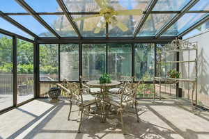 Sunroom / solarium featuring healthy amount of natural light, outdoor dining space, and a ceiling fan