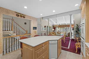 Kitchen featuring wallpapered walls, light tile patterned floors, recessed lighting, light countertops, and a kitchen bar