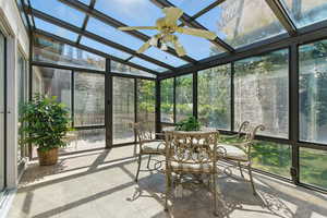 Sunroom / solarium with ceiling fan, healthy amount of natural light, and lofted ceiling