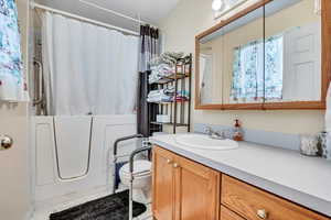 Bathroom featuring vanity, toilet, and shower / bath combination with curtain