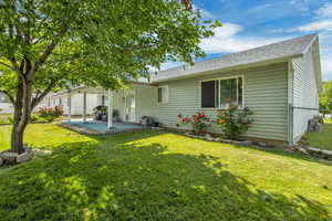 Rear view of house with a patio area and a shingled roof