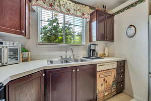 Kitchen with a sink, light countertops, and white dishwasher