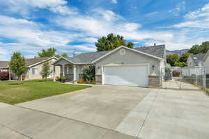 Ranch-style house with stucco siding, concrete driveway, a garage, a shingled roof, and a mountain view